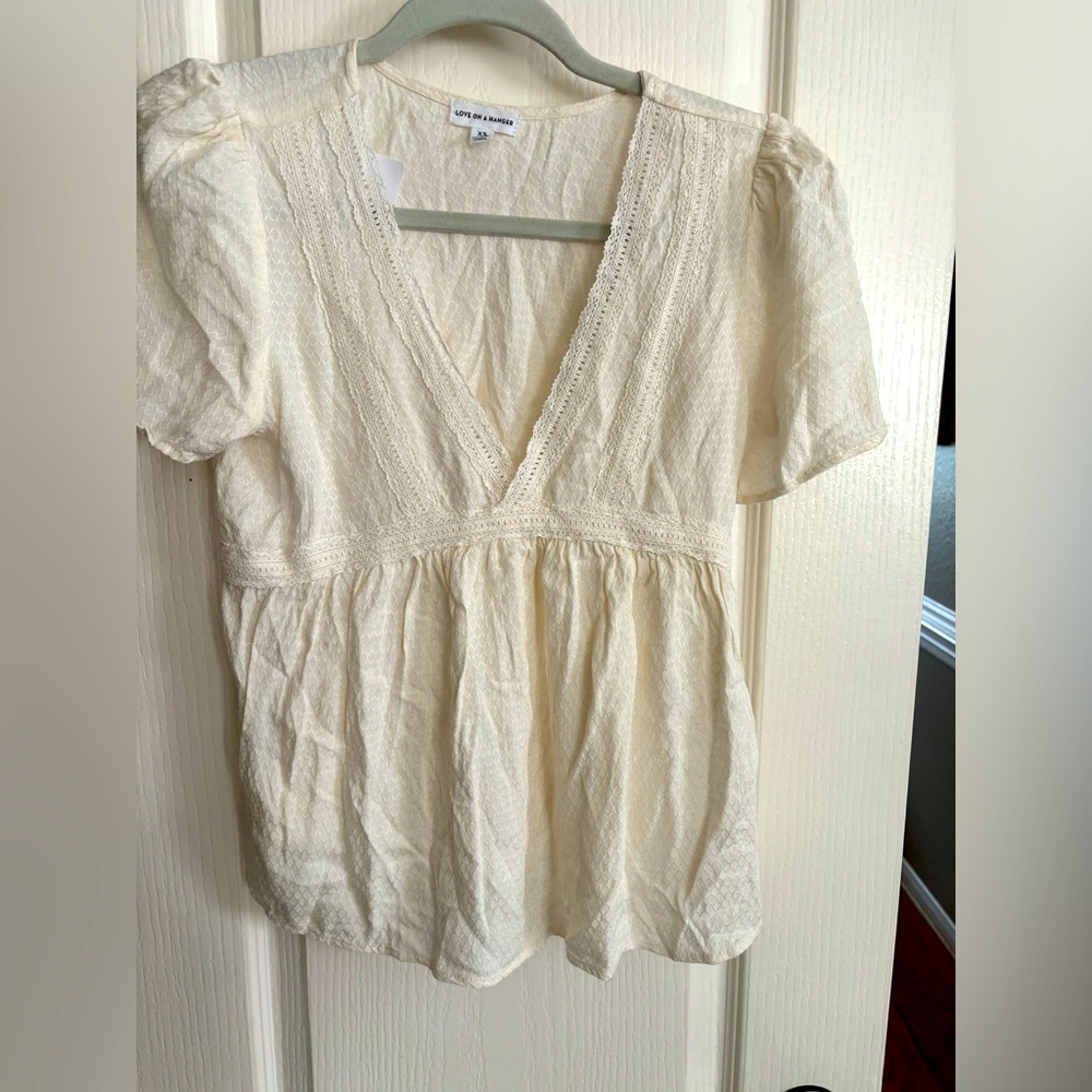 love on a hanger. Says extra small. Very cute cream colored cropped‎ shirt